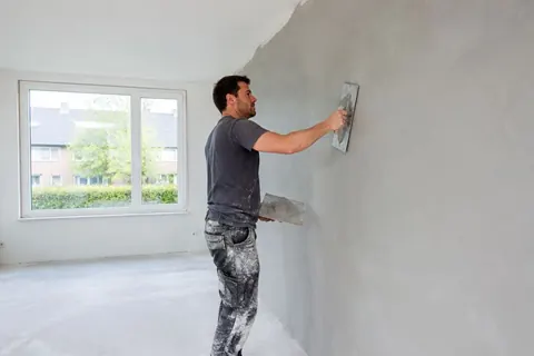 Plasterer smoothing a wall